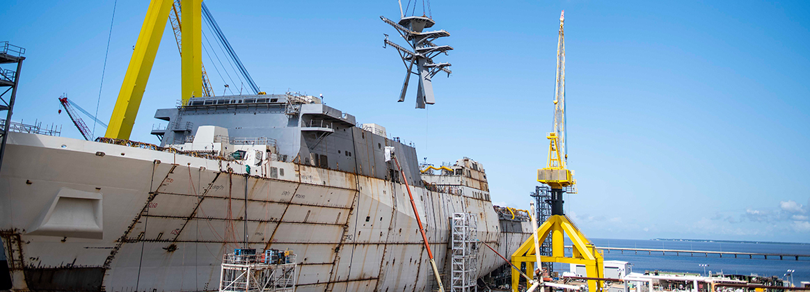 Shipbuilders lift the mast onto the amphibious transport dock Richard M. McCool Jr. (LPD 29).